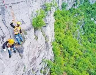 捅山工百米高空作業(yè)，為保障山下列車通行安全